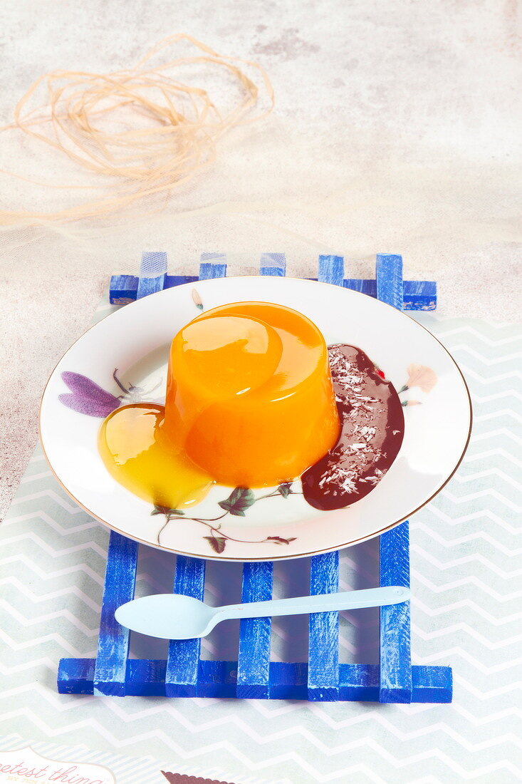 Orangenwackelpudding mit Schokoladensauce und Kokosraspeln