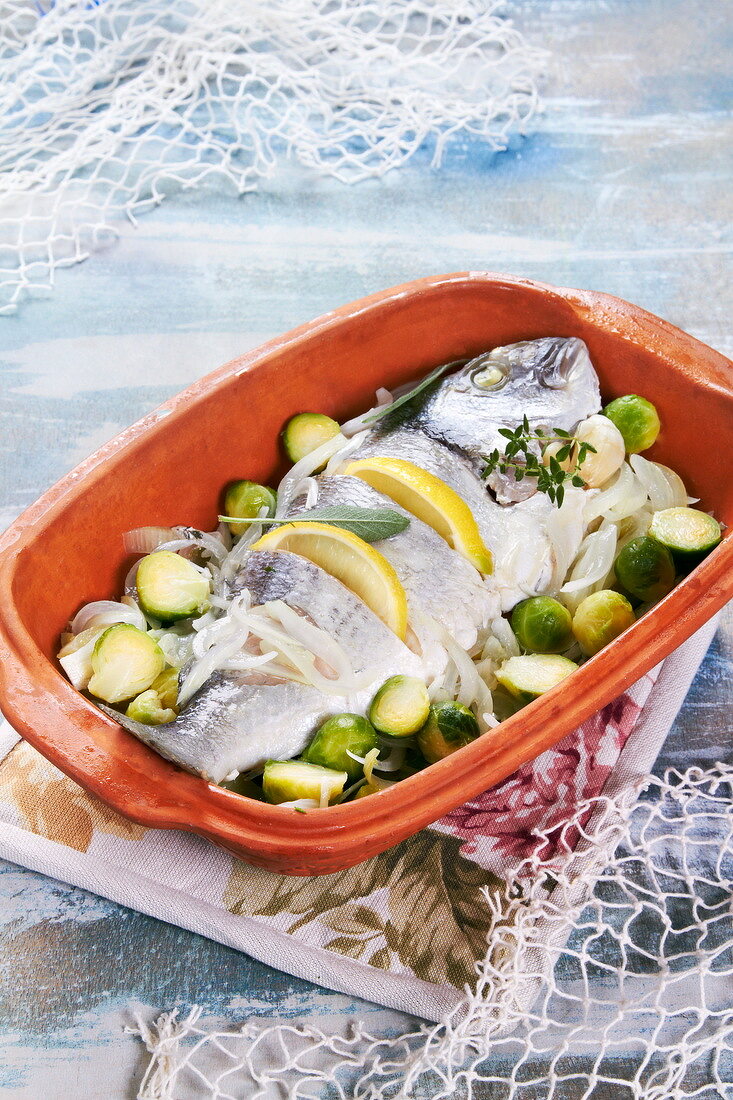 Oven-baked sea bream with onions, lemons and Brussel sprouts
