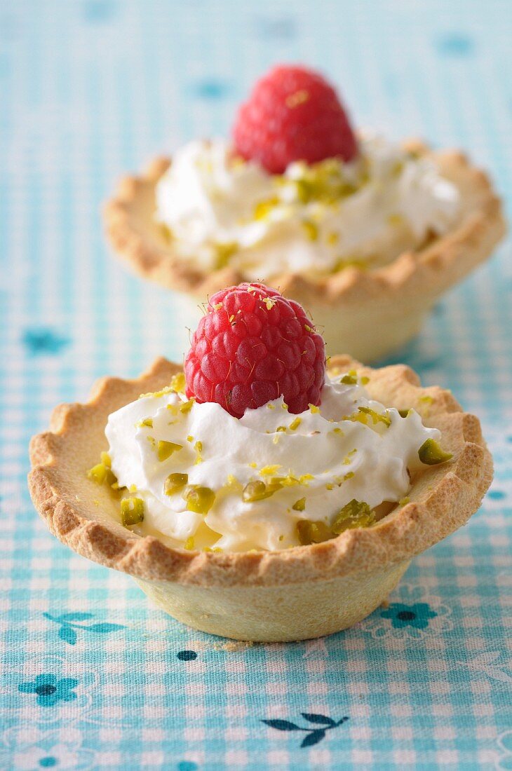 Whipped cream,crushed pistachio and raspberry tartlets