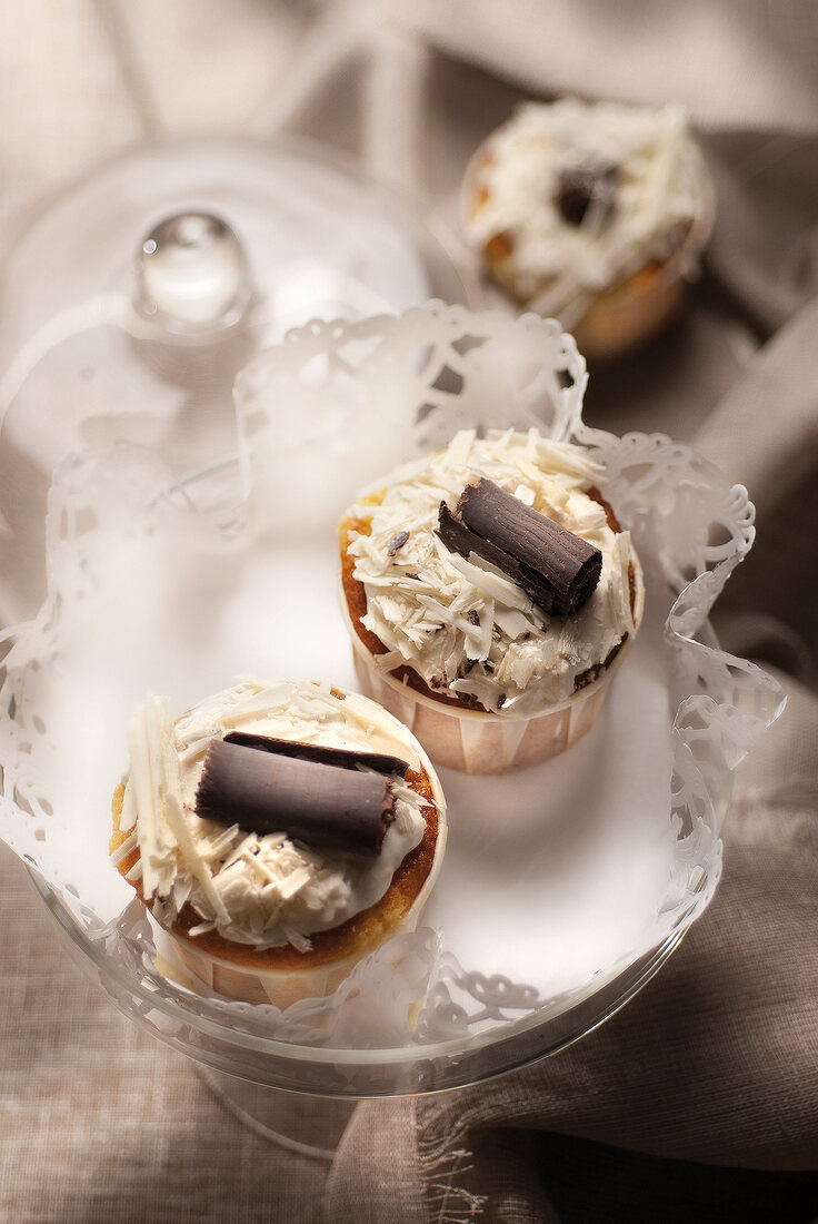 Zwei Schokoladen-Cupcakes mit weissen Schokoraspeln