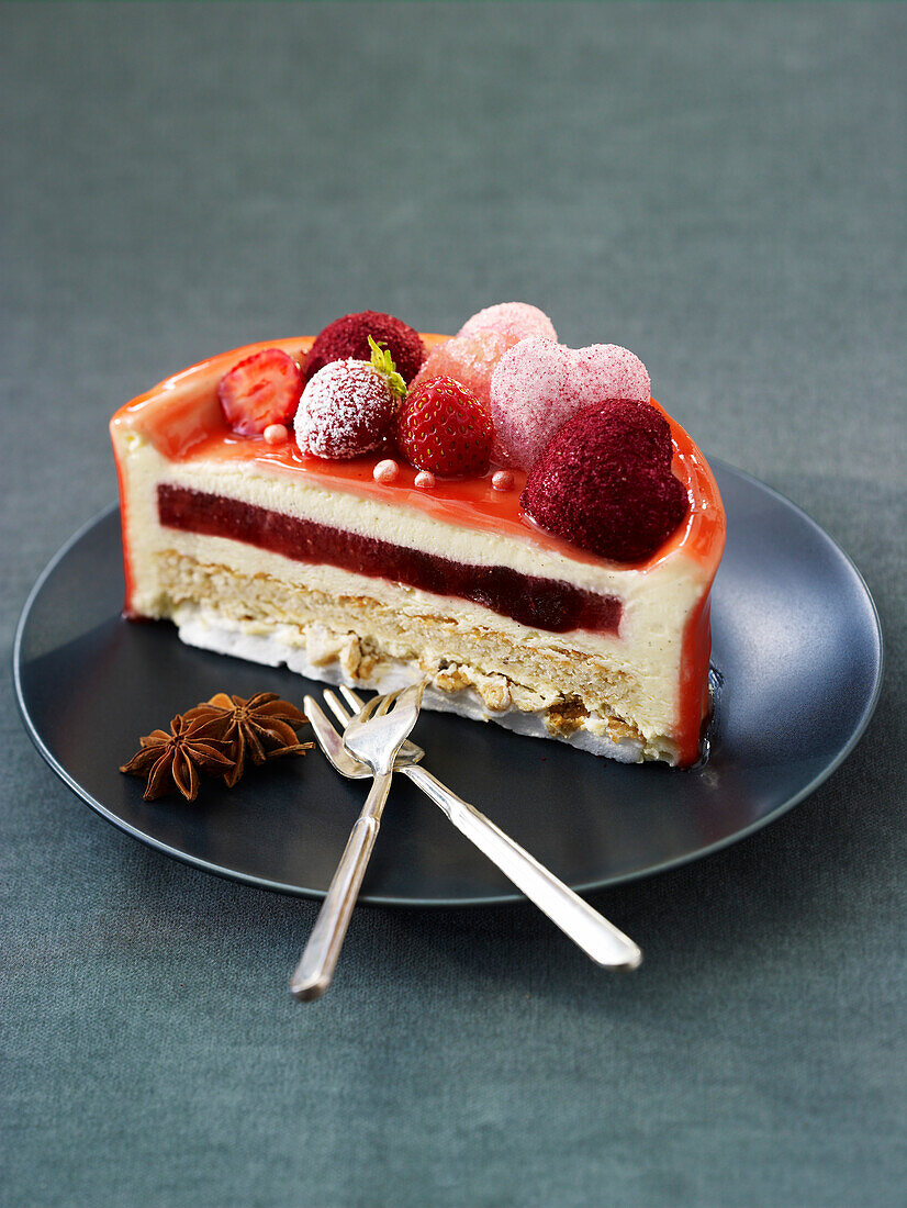 Schichtdessert mit Sommerfrüchten und Sternanis auf schwarzem Teller