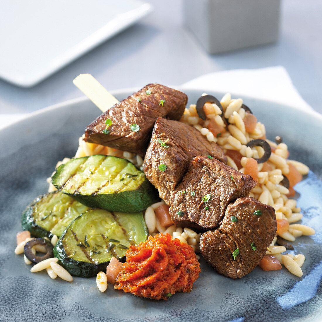 Rindfleischspiess mit Thymian, gegrillten Zucchini, Nudeln mit schwarzen Oliven und Tomatentapenade