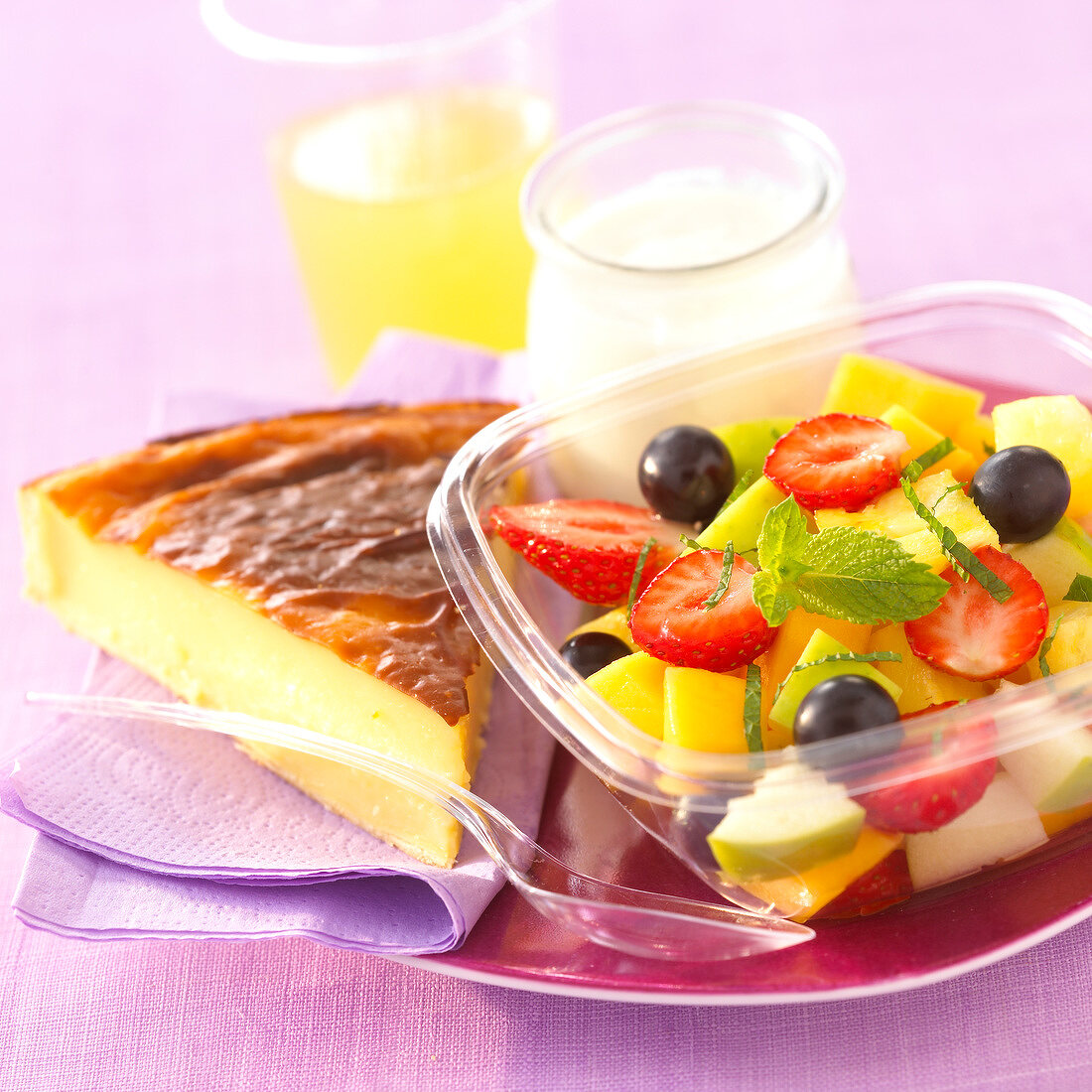 Frischer Obstsalat mit einem Stück Kuchen, Joghurt und Orangensaft
