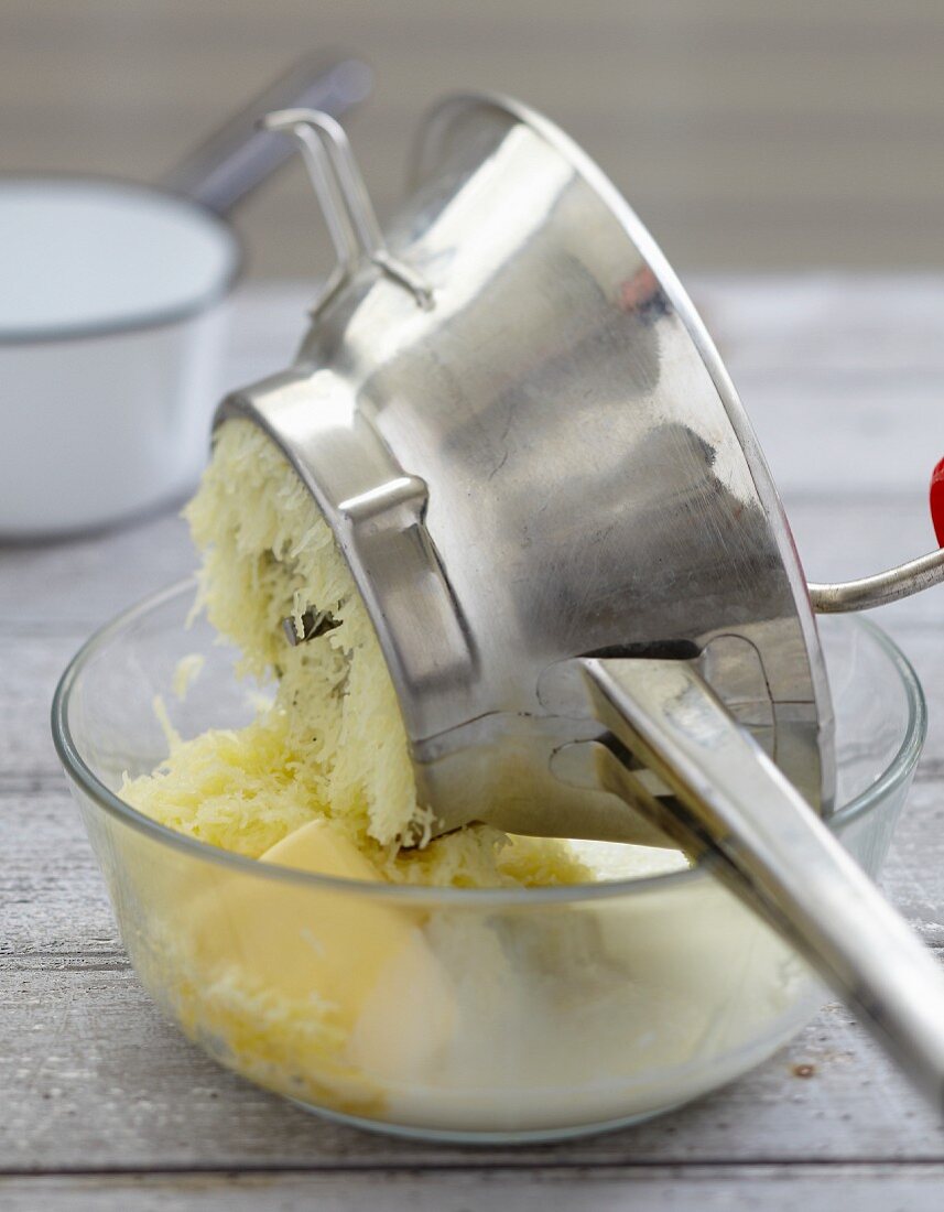 Mashing the potatoes with a puree maker