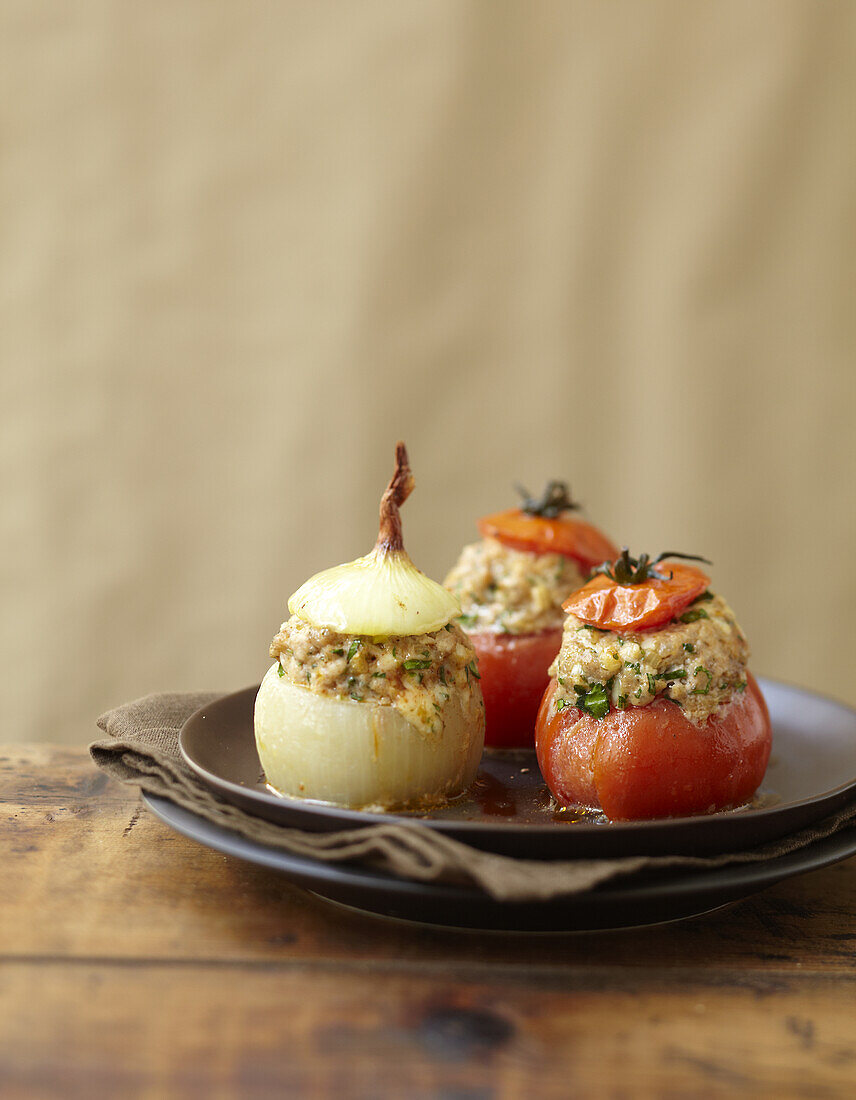 Mit Fleisch und Käse gefüllte Tomaten und Zwiebeln