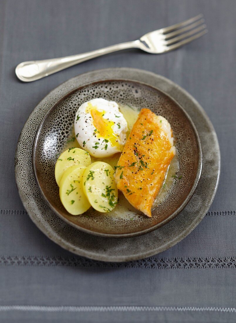 Haddock with a poached egg and potatoes with chopped parsley