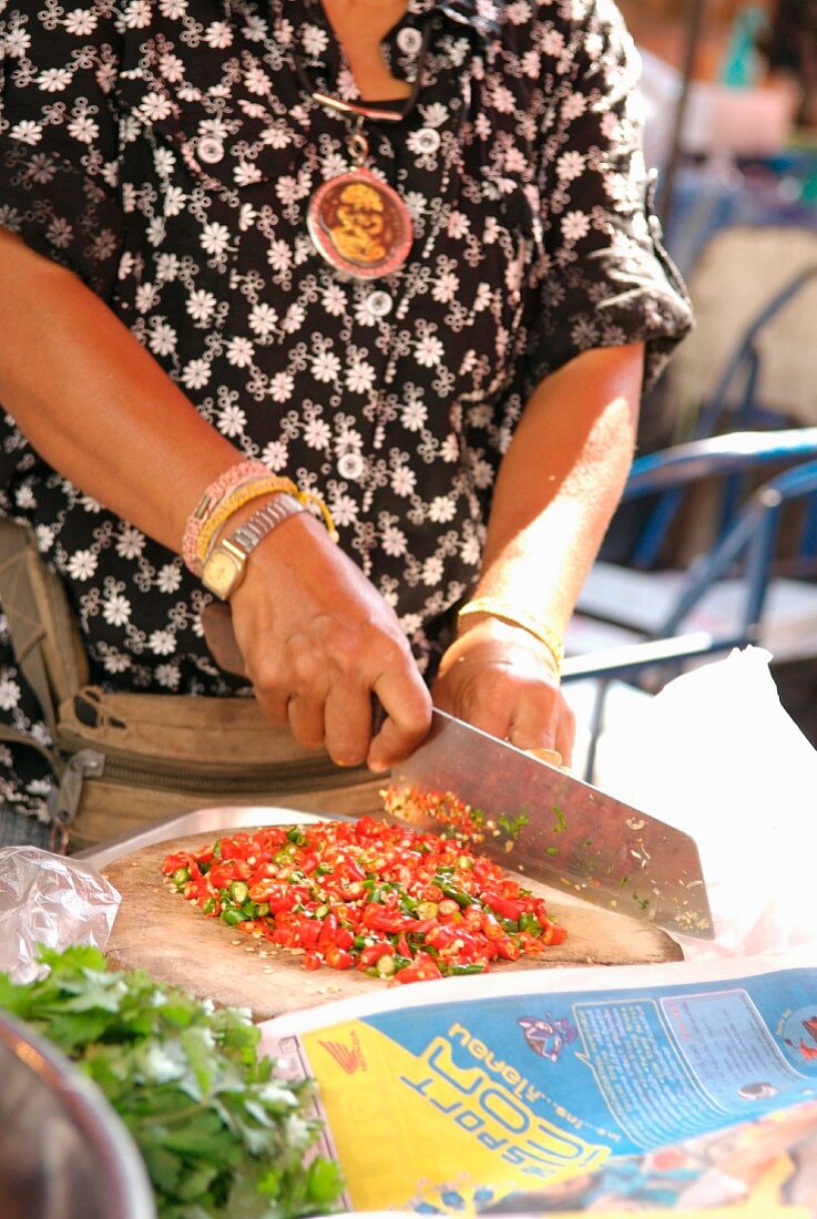 Woman preparing peppers in the street