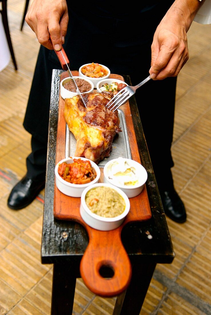 Kellner tranchiert Fleisch im Restaurant La Cabrera in Buenos Aires