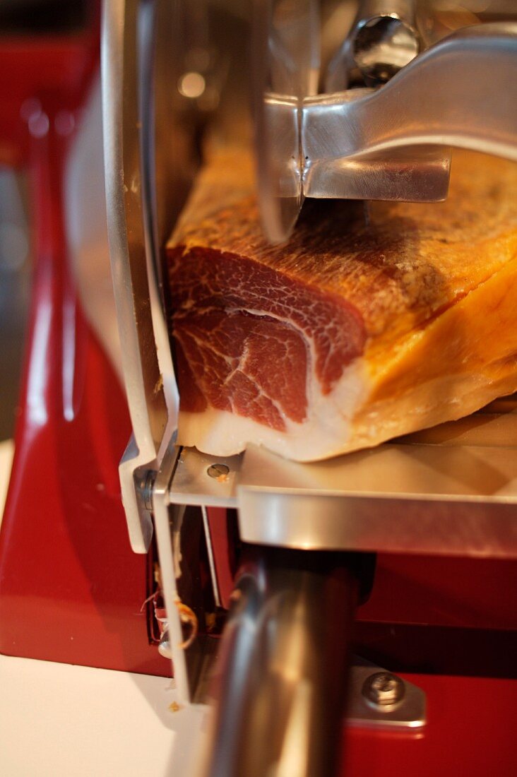 Slicing raw ham with a slicing machine