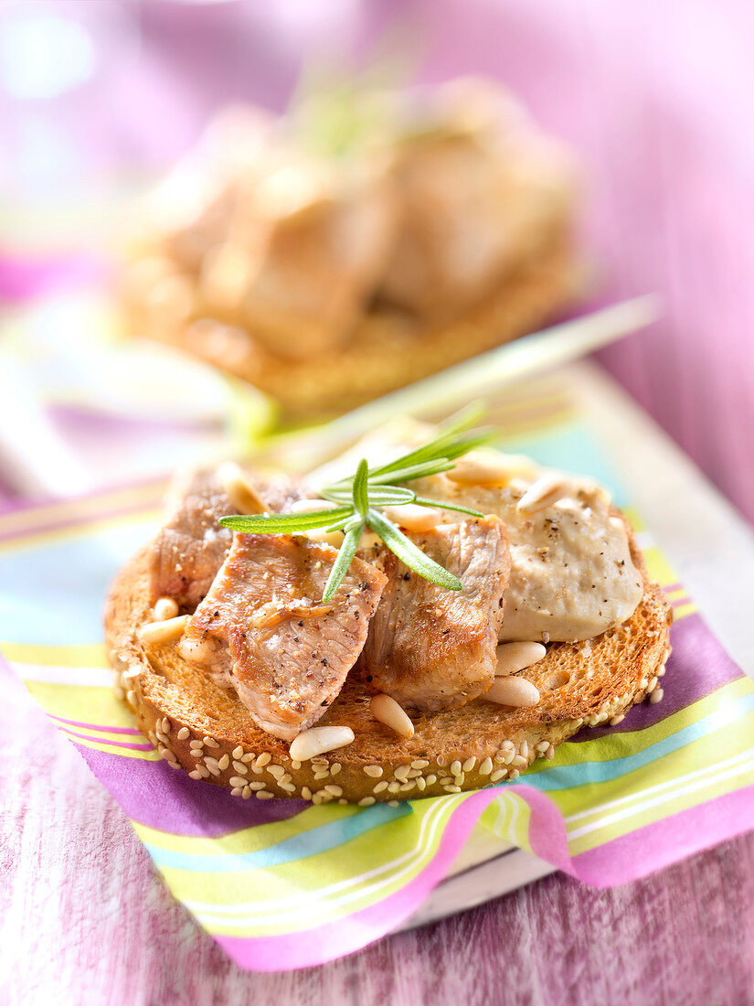 Belegtes Brot mit Hummus, Kalbspicatta und Pinienkernen