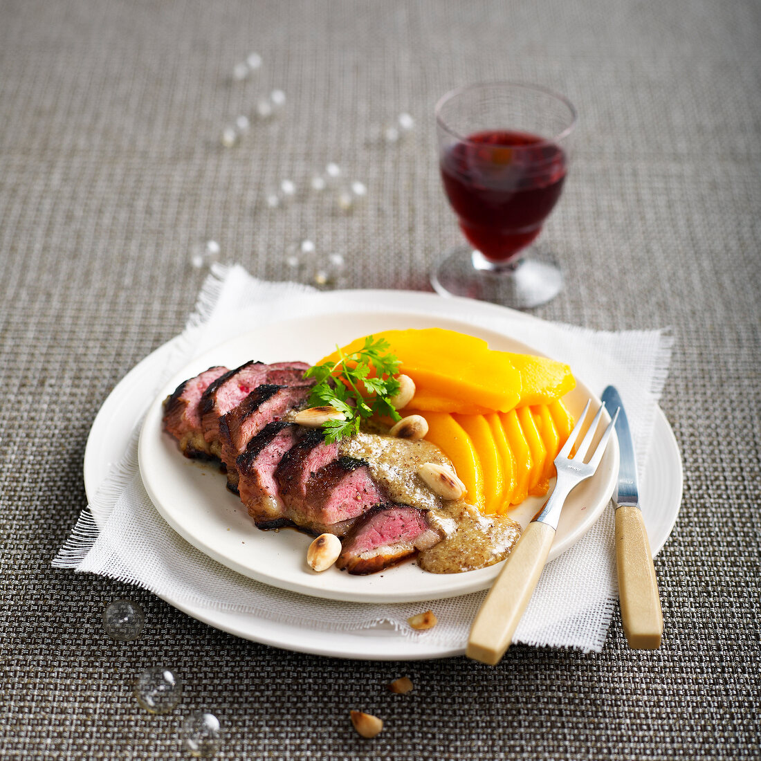 Duck fillets with almond sauce and thinly sliced mango