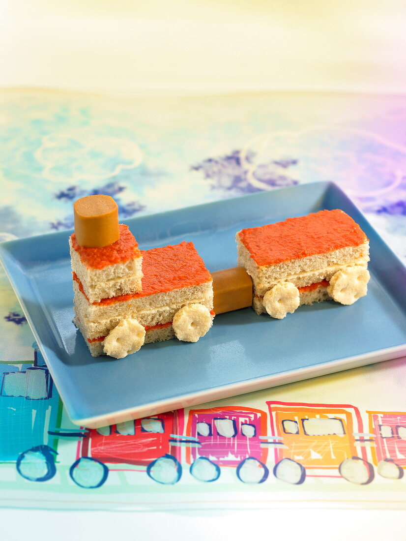 Kids' sandwich in train shape with crackers, sausages, pepper cream and mayonnaise
