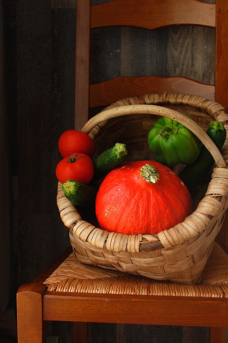 Korb mit Kürbis, Zucchini, Tomaten und Paprika