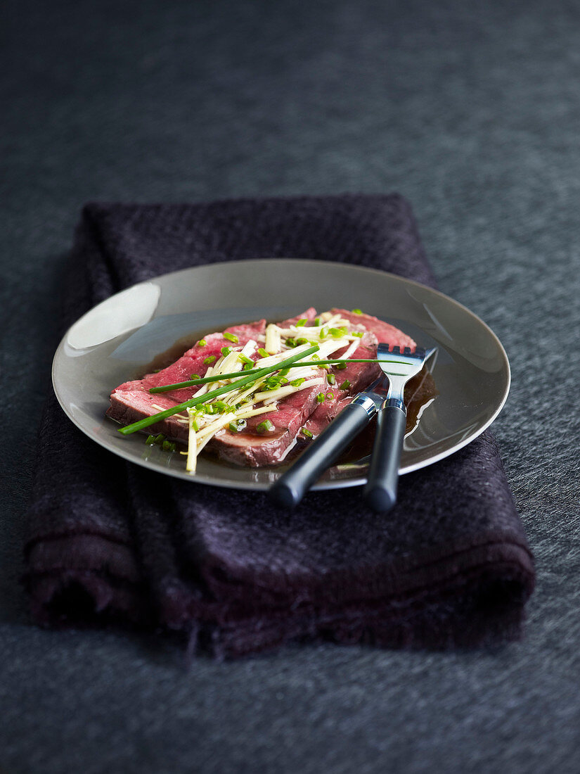 Cold sliced roast beef with lemon grass and chives