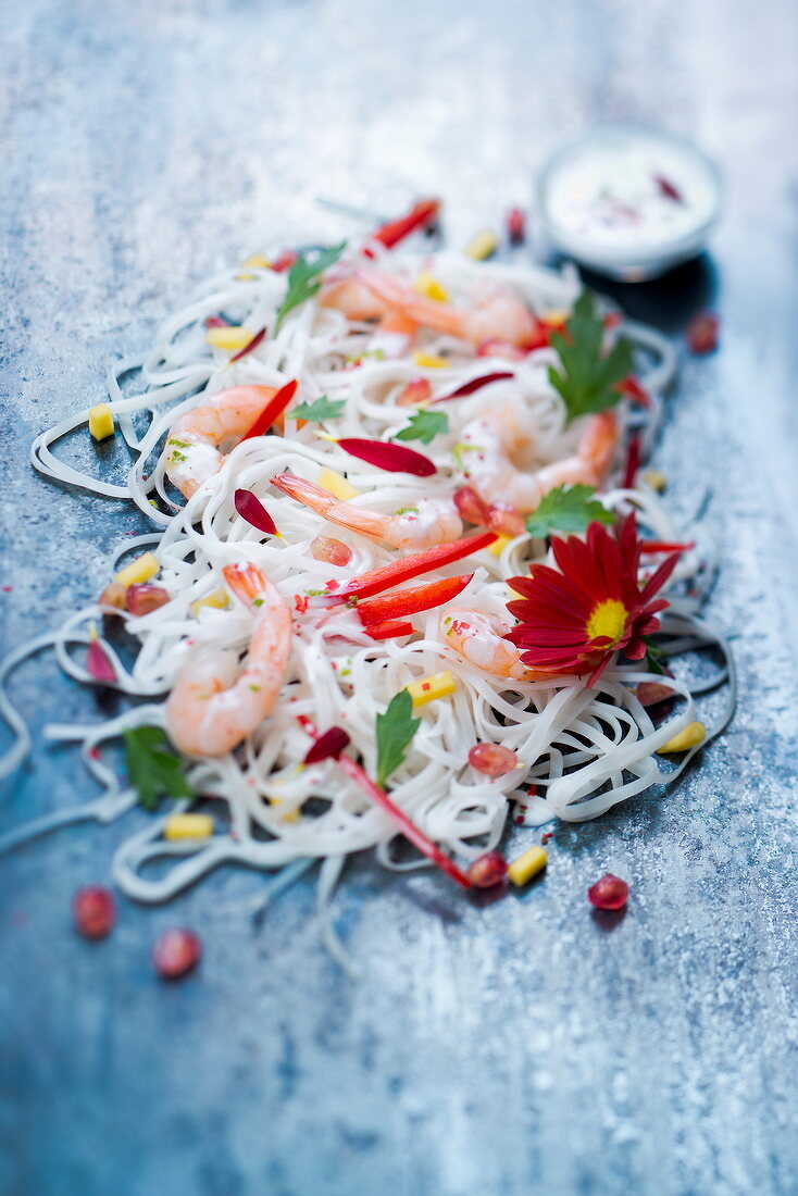 Salat mit Reisnudeln, Riesengarnelen, Paprika und roten Margeriten