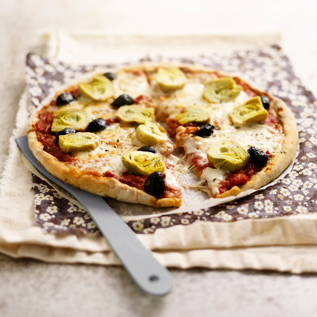 Pizza mit Artischocken, Oliven und Mozzarella