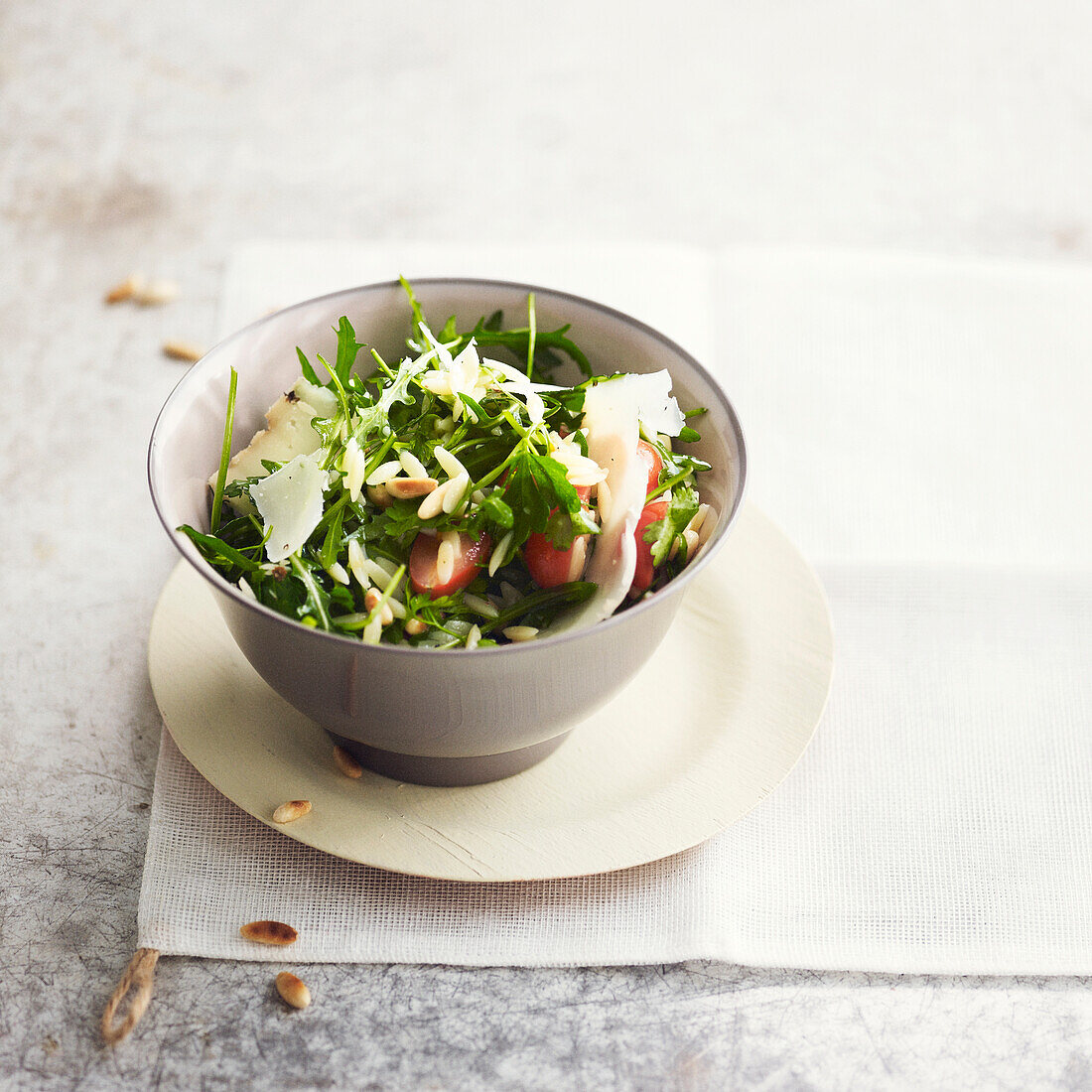 Rucola mit Kritharaki, Trauben, Tomaten, Käse und Pinienkernen (vegetarisch)