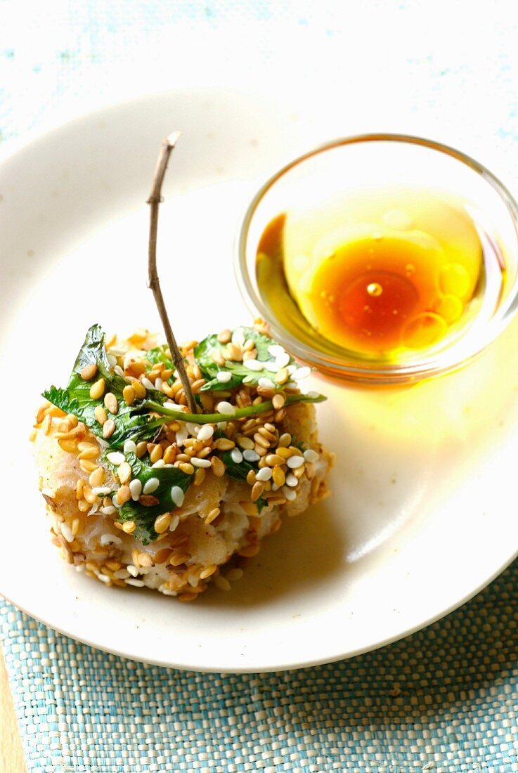 Fishball coated in white and golden sesame seeds and cilantro