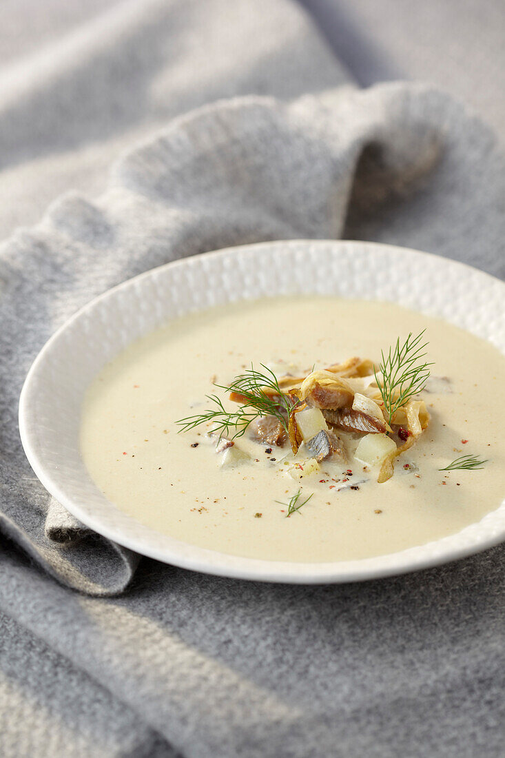 Cream of chicory soup with herring potato salad as topping