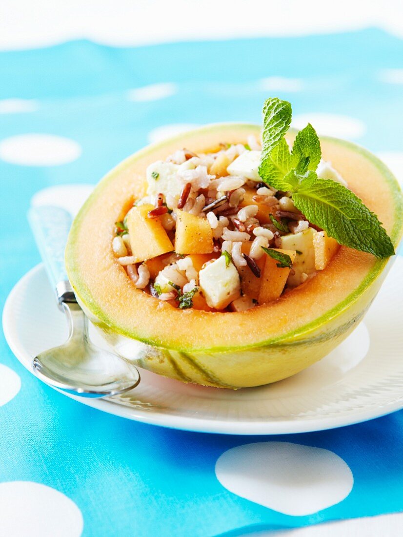 Two types of rice,melon and cheese salad served in a melon shell