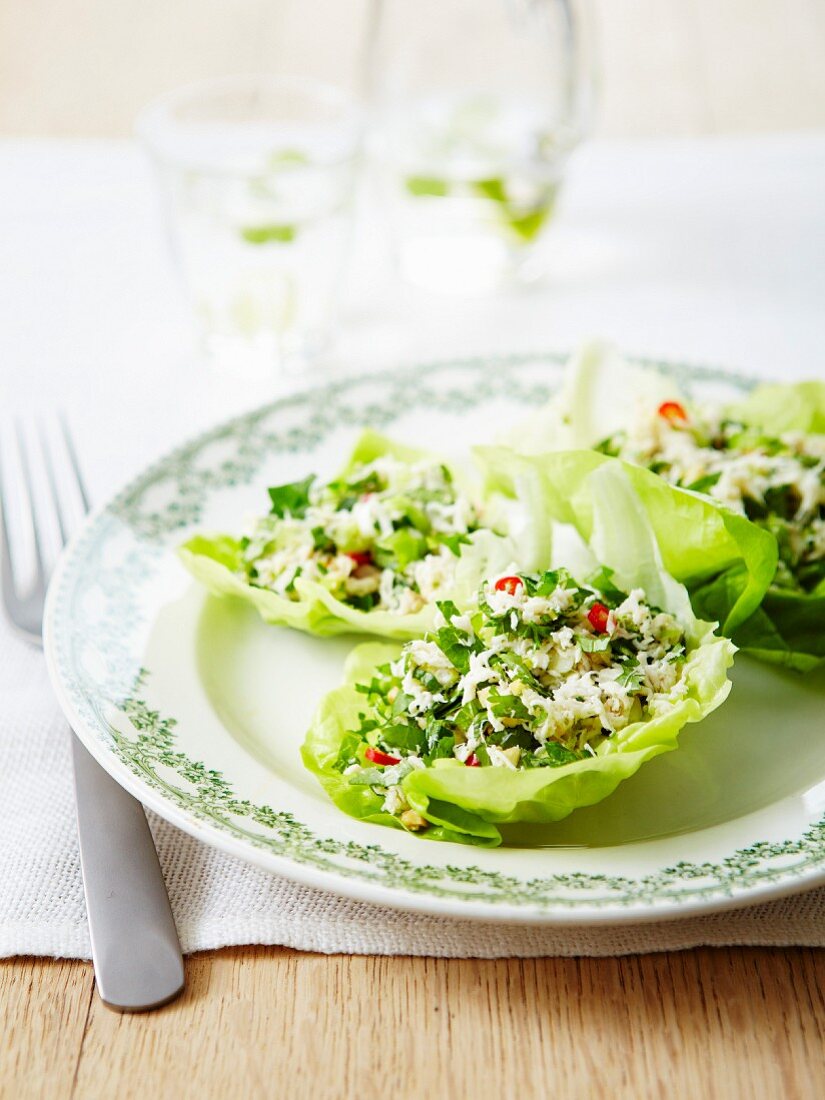 Flaked crab meat salad with herbs and chili pepper served in lettuce leaves