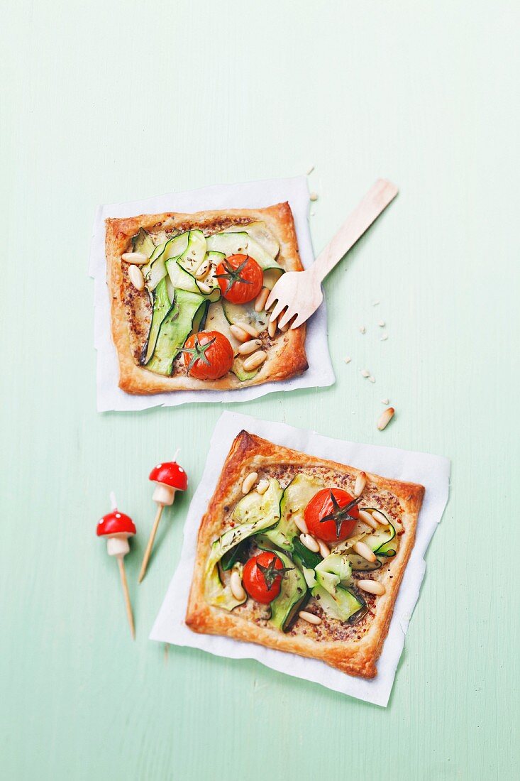 Mini-Pizza mit Zucchini, Tomaten und Pinienkernen