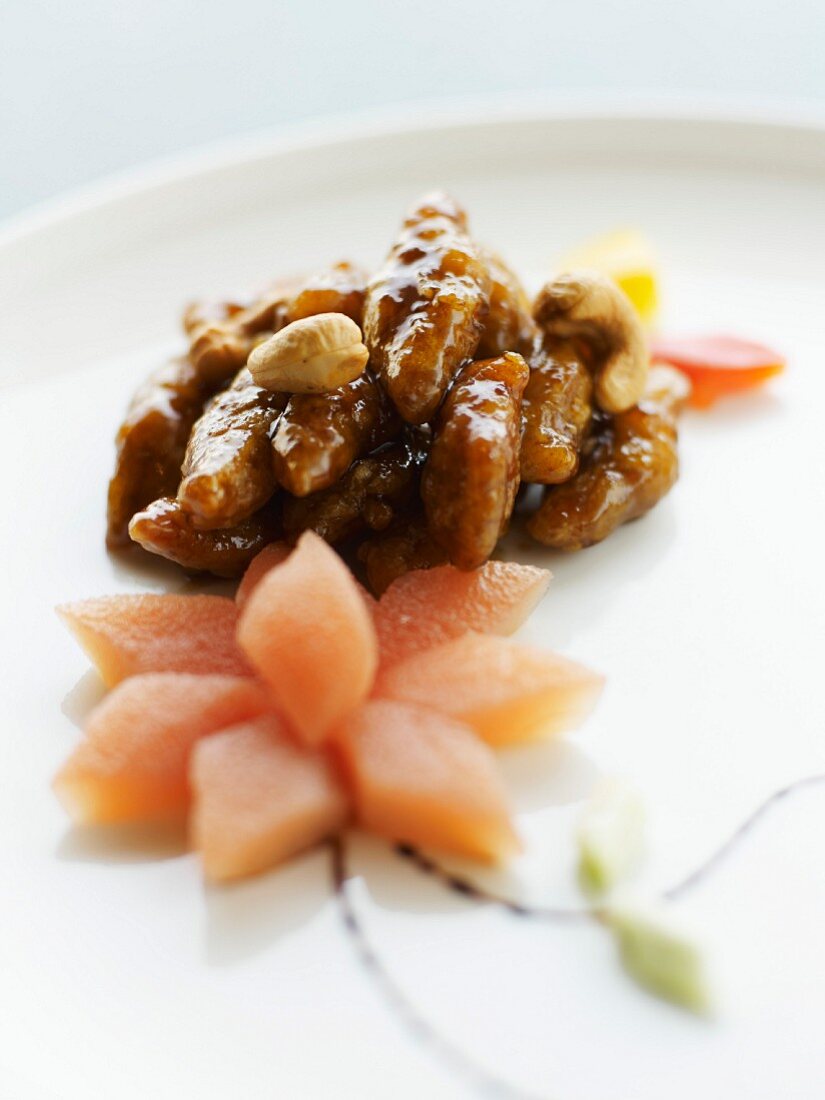 Schweinefleisch mit karamellisierten Trockenfrüchten, Blume aus kandierter Papaya