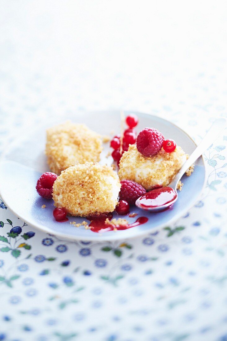 Ricotta balls coated with grated almonds and served with forest fruit coulis