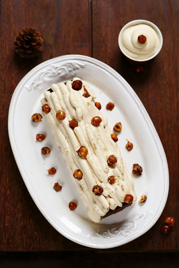 Cocoa,caramel whipped cream and gluten-free caramelized hazelnut log cake