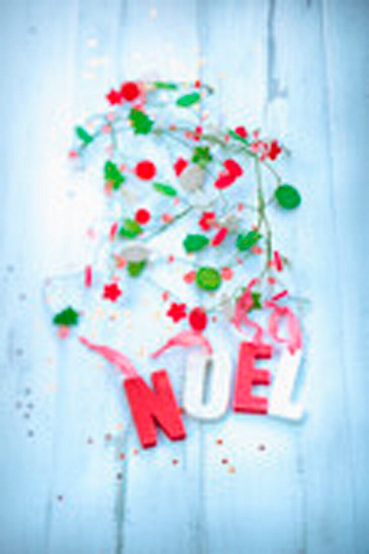 Christmas garlands and the word Noel written in wooden letters