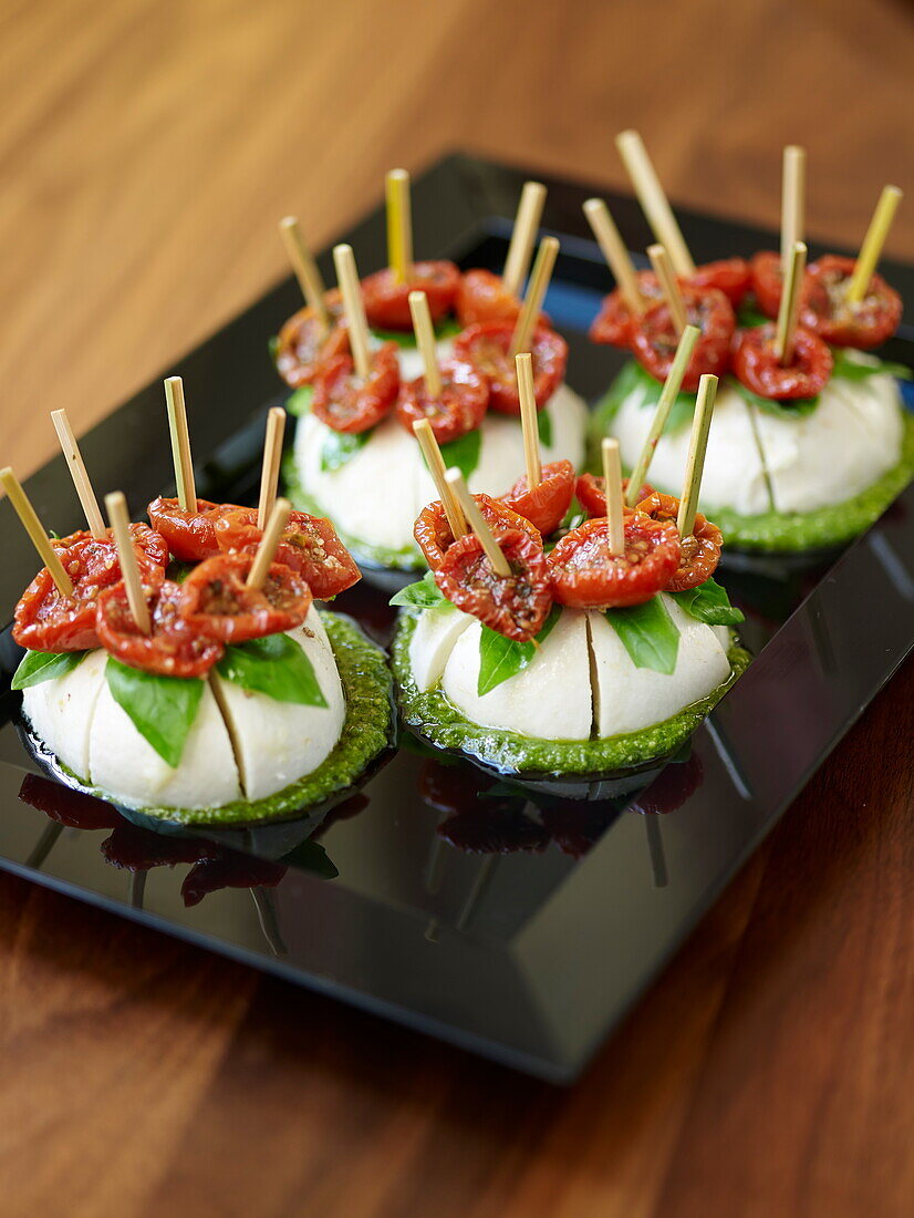 Büffelmozzarella mit getrockneten Tomaten auf Pesto als Fingerfood