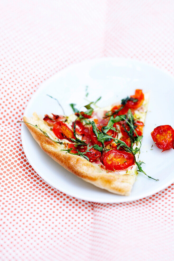 Ein Stück Pizza mit Kirschtomaten