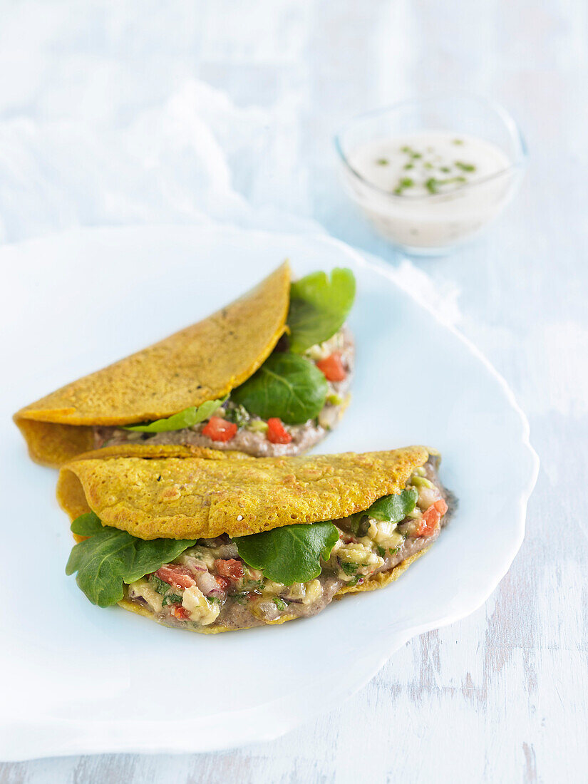 Gluten-free pancakes stuffed with lentils, guacamole and tomatoes