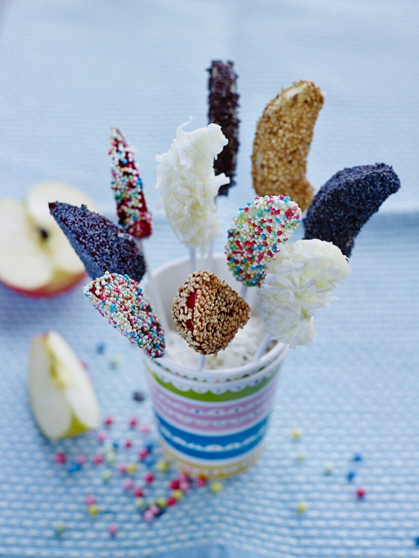 Fruit lollies decorated with colourful sugar sprinkles and seeds