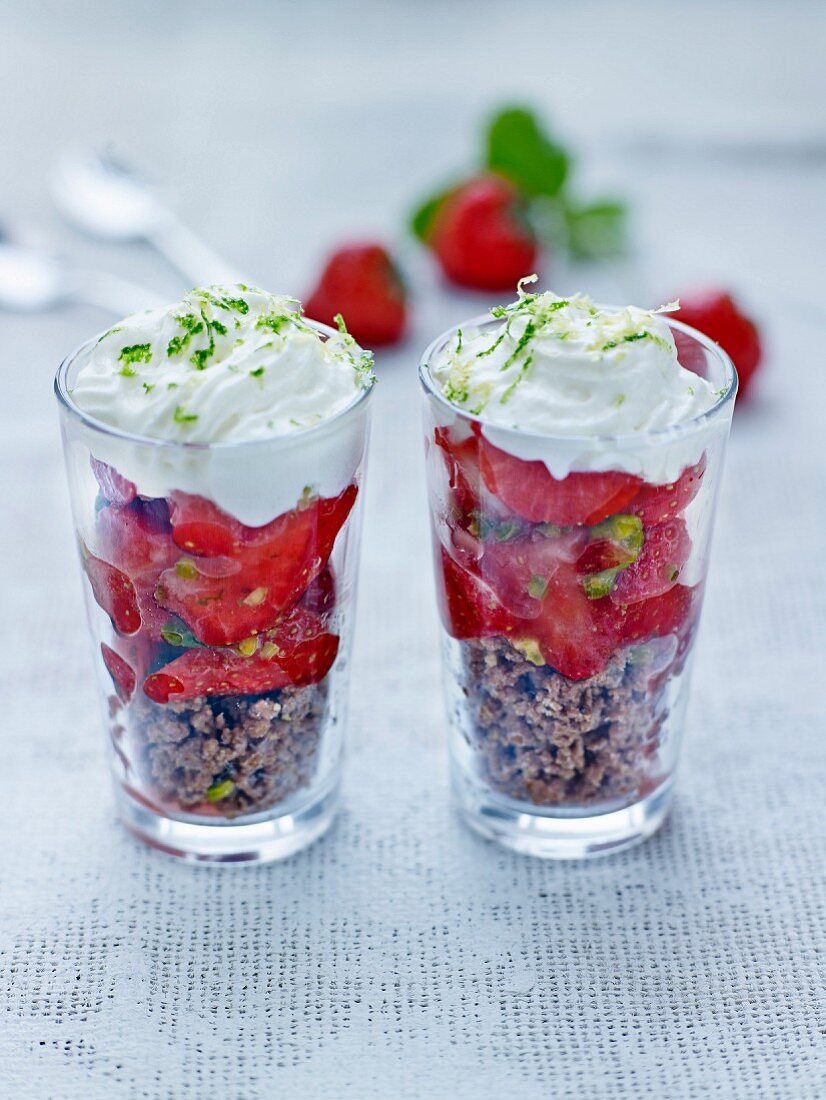 Cereal and strawberry dessert with lime zest in glasses