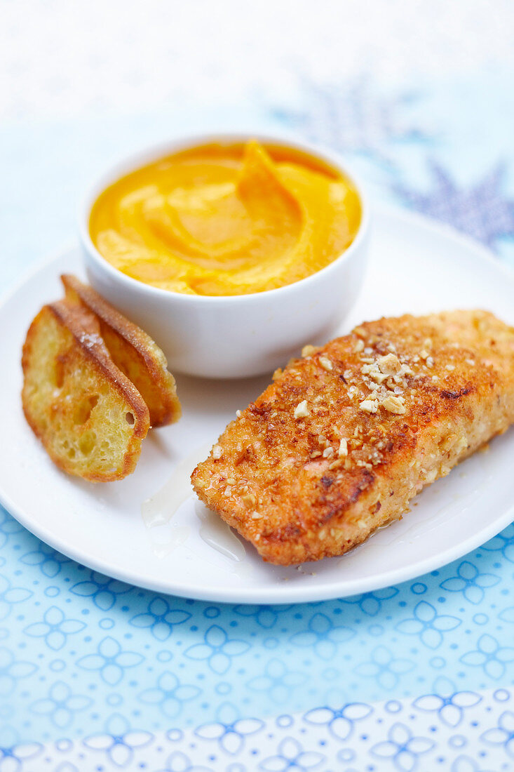 Thick piece of salmon breaded with crushed hazelnuts, smooth carrot puree