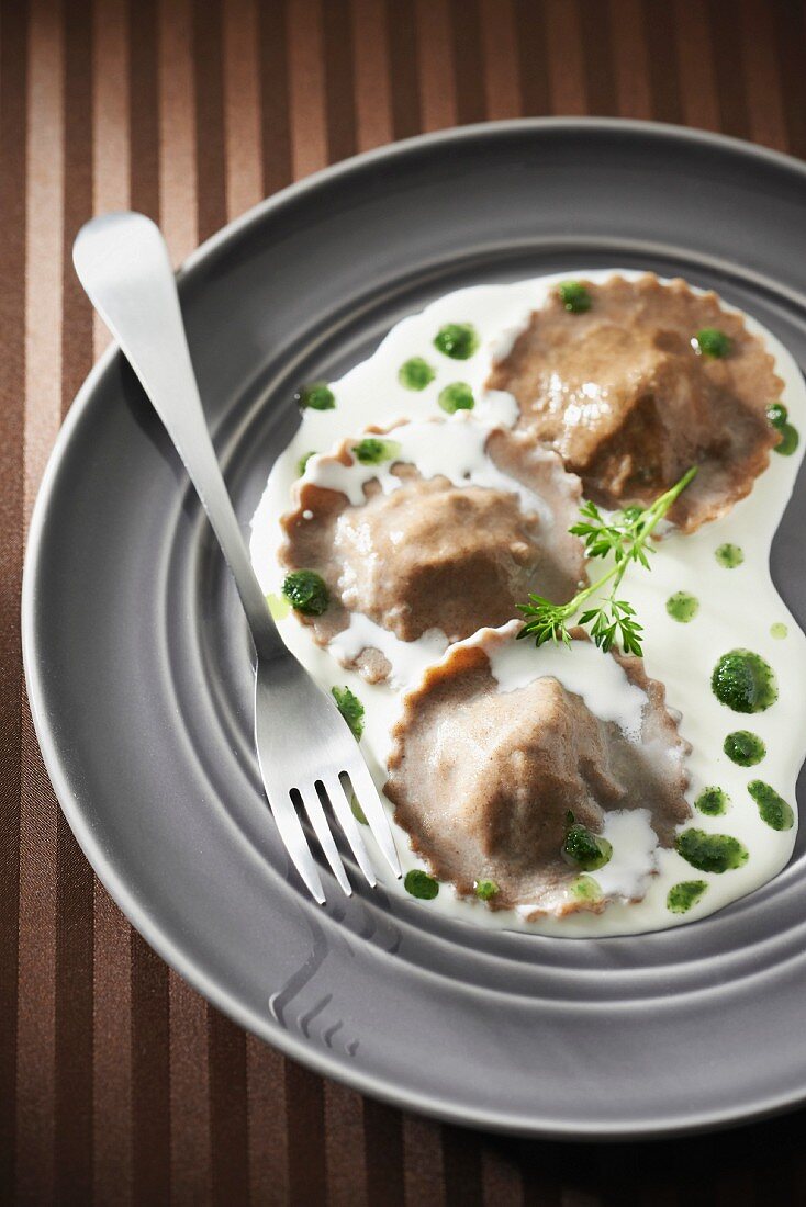 Snail buckwheat raviolis,creamy garlic sauce with parsley oil