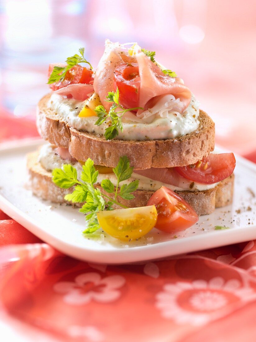 Ziegenkäse, Rohschinken und Tomaten auf Röstbrot