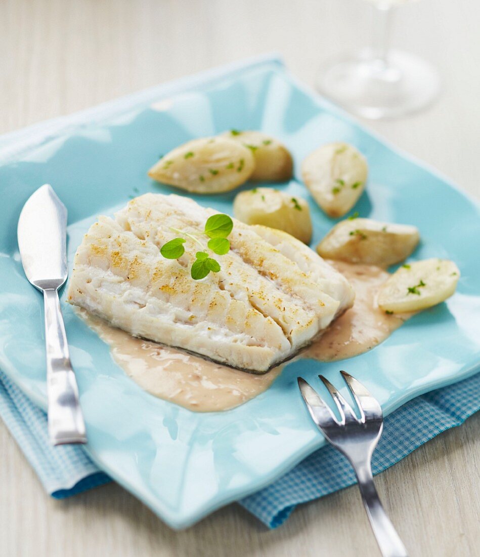 Pike fillet in creamy sauce and potatoes with parsley