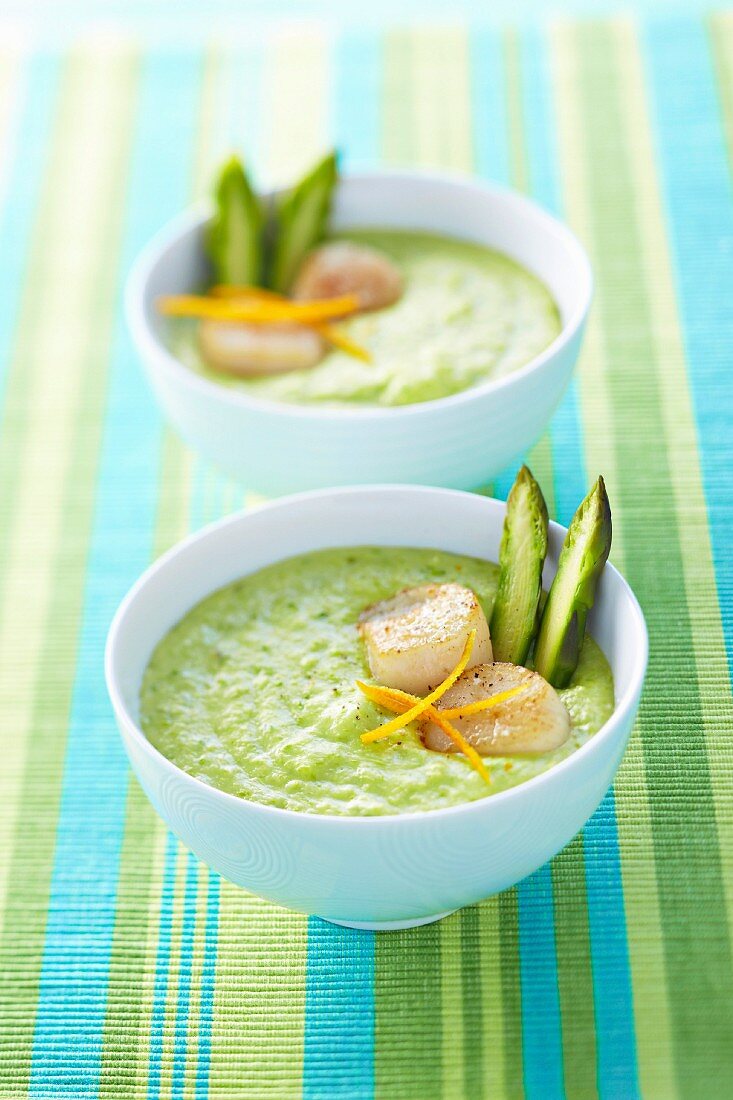 Cream of green asparagus soup with scallops and orange zests