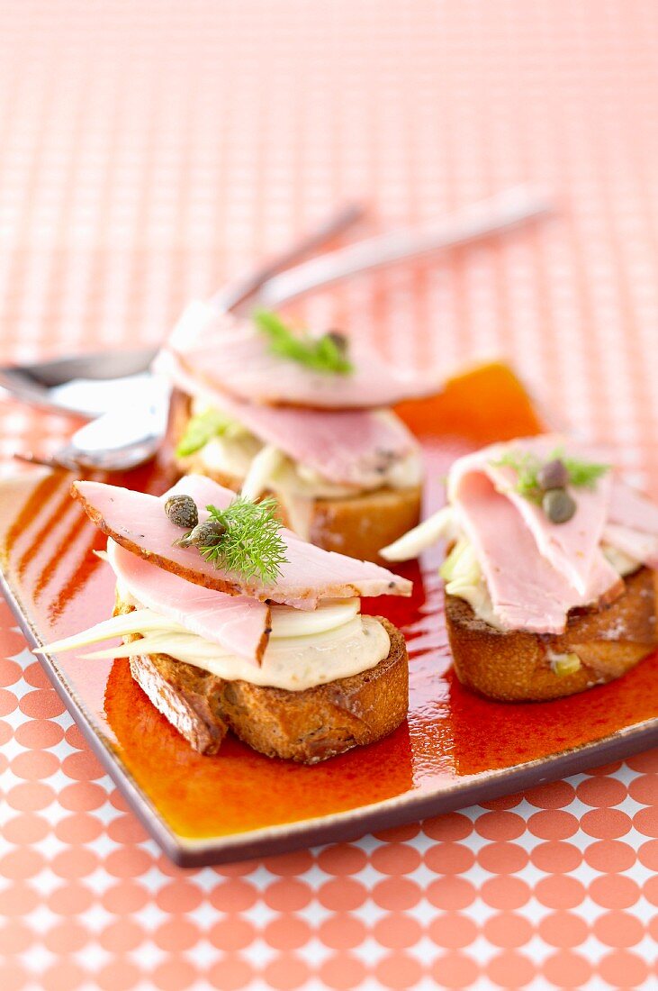 Slices of roasted veal,fennel and tuna cream with capers Crostinis