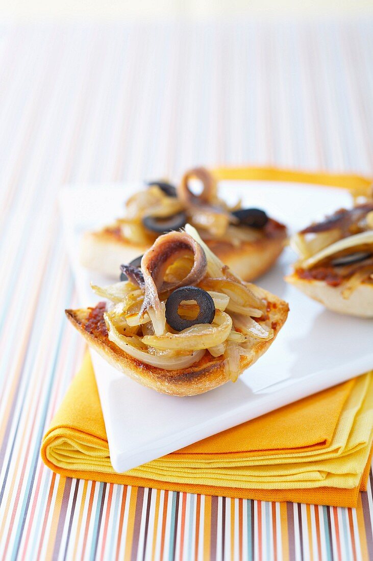 Simmered onions,black olives and anchovies on ciabatta bread