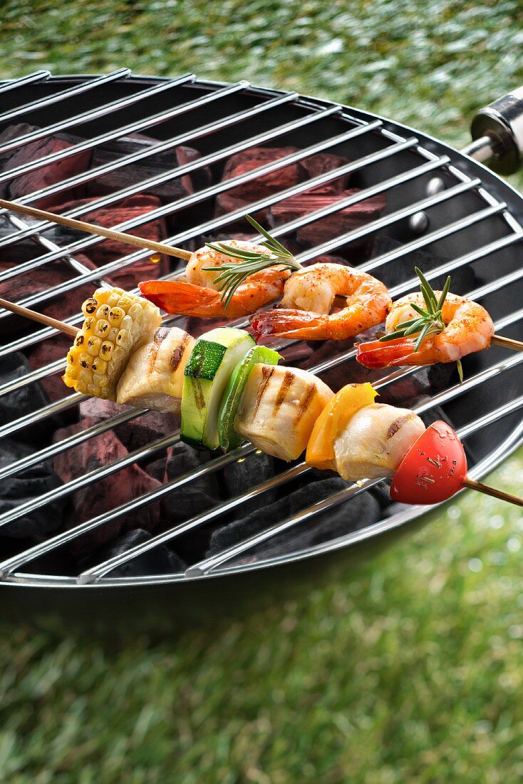 Garnelen-Hähnchen-Spiesse auf einem Grill im Freien