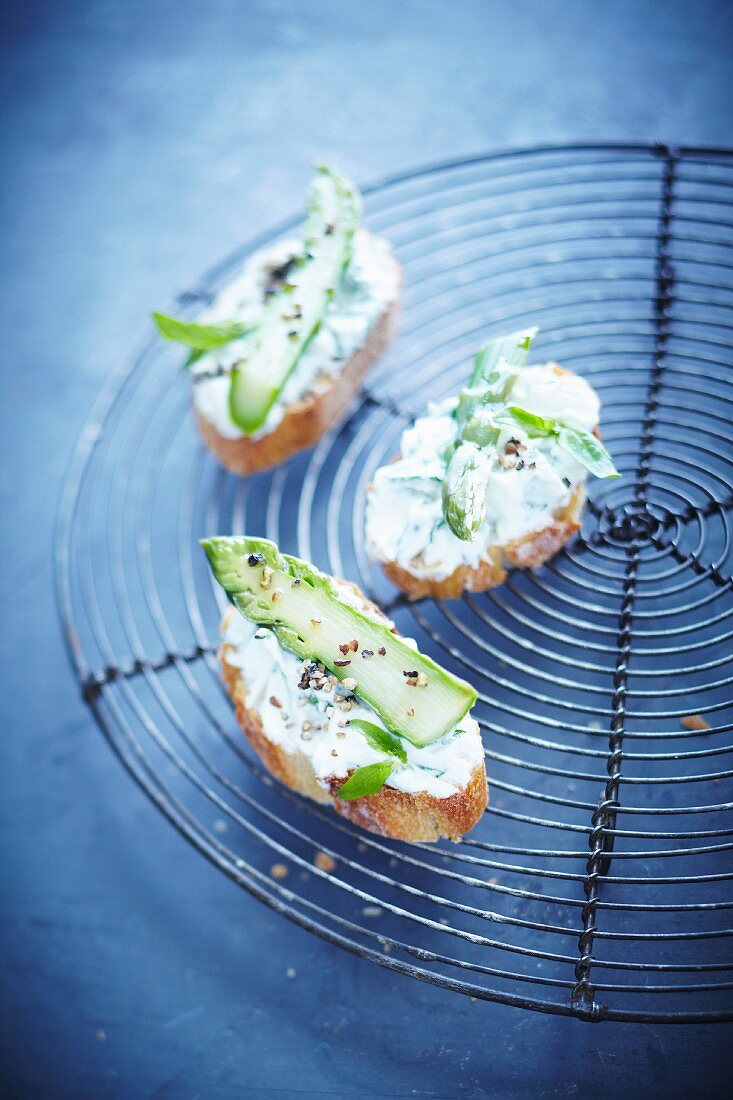 Slices of bread topped with cream cheese and green asparagus