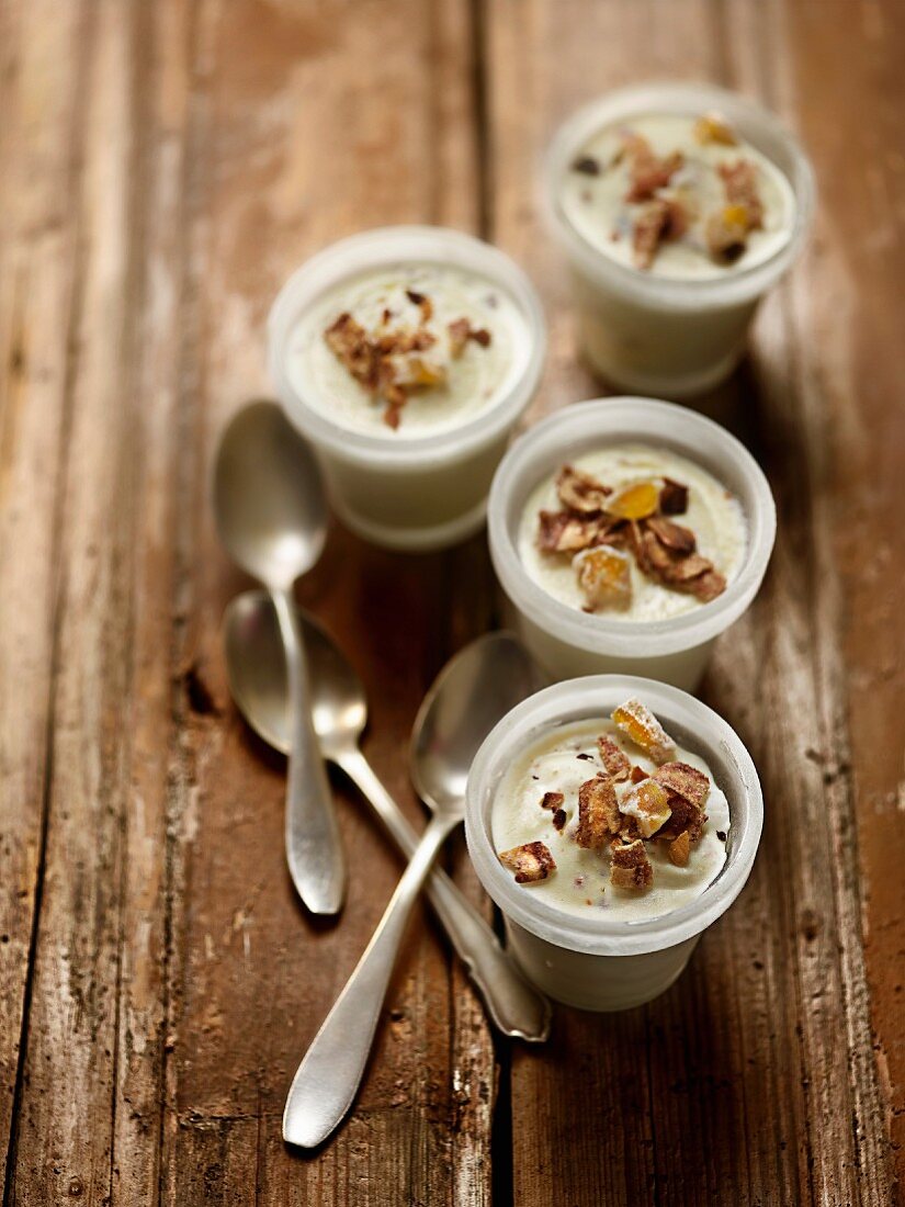 Gefrorene Vanillecreme mit kandierten Früchten und getrockneten Bananen, in Gläsern serviert