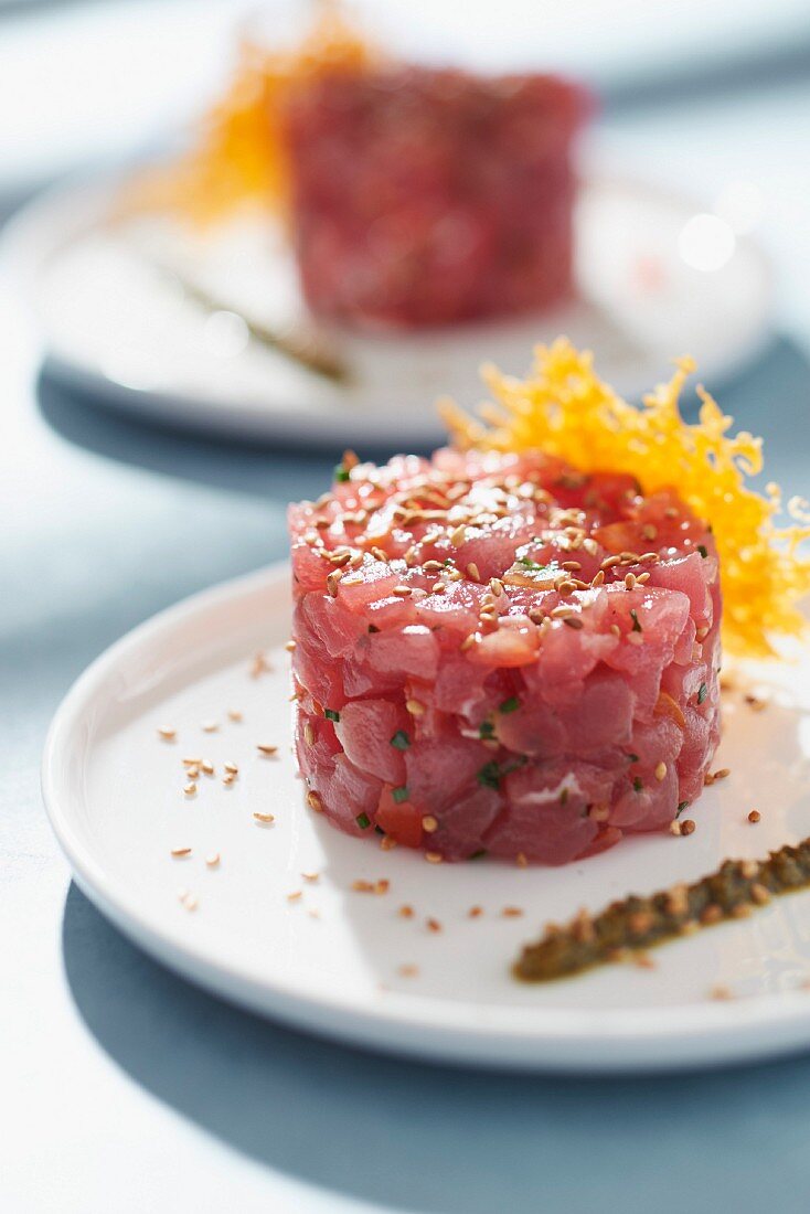 Thunfisch-Tatar mit Pesto und Hippe von gereiftem Mimolettekäse