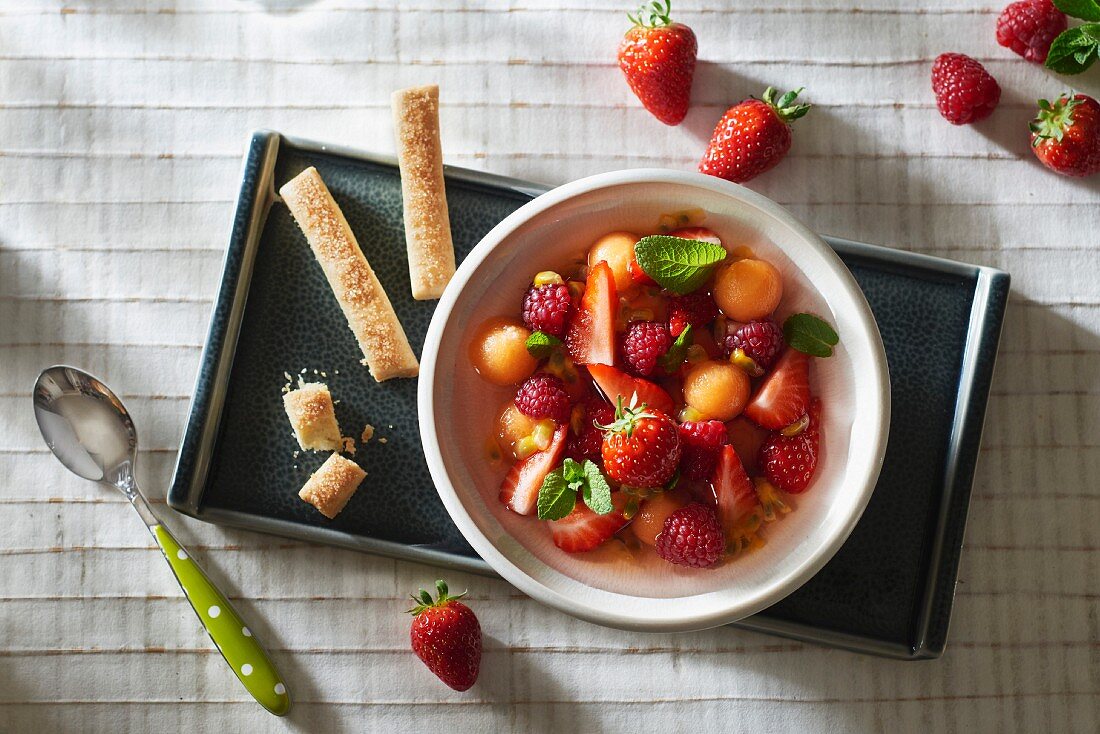 Obstsuppe mit Erdbeeren, Himbeeren, Melone und Minze