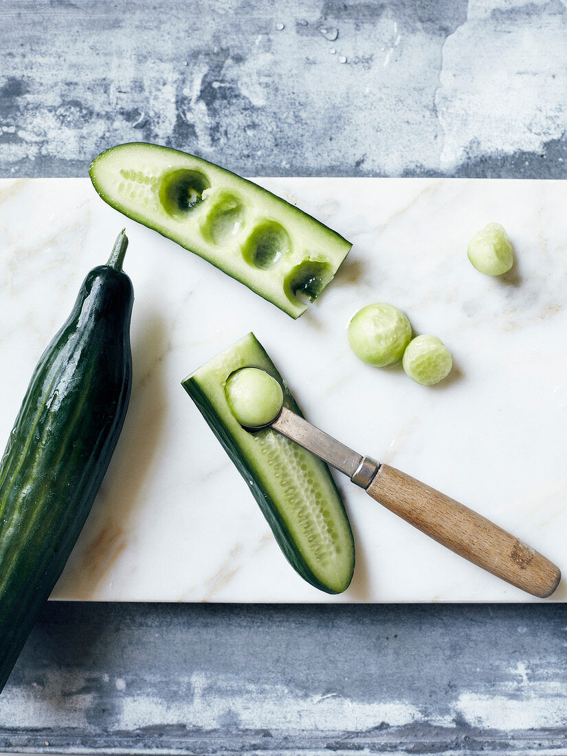 Using a melon baller to make cucumber balls