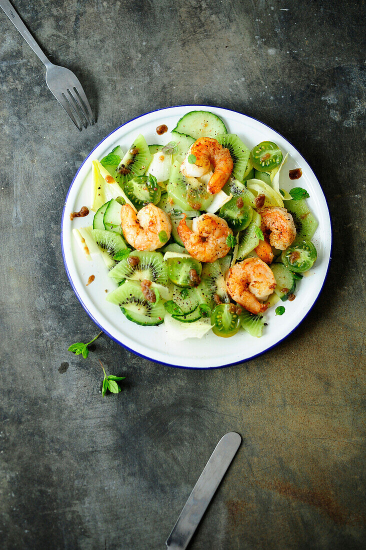 Salat mit Kiwi, grünen Kirschtomaten, Gurke und Garnelen