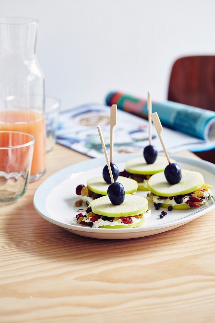 Sticks mit Apfel, Frischkäse, getrockenten Waldfrüchten und Trauben